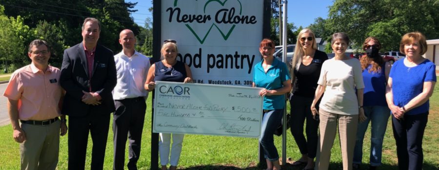 Cherokee Association of REALTORS® Give Back to the Community With a Donation to Never Alone Food Pantry