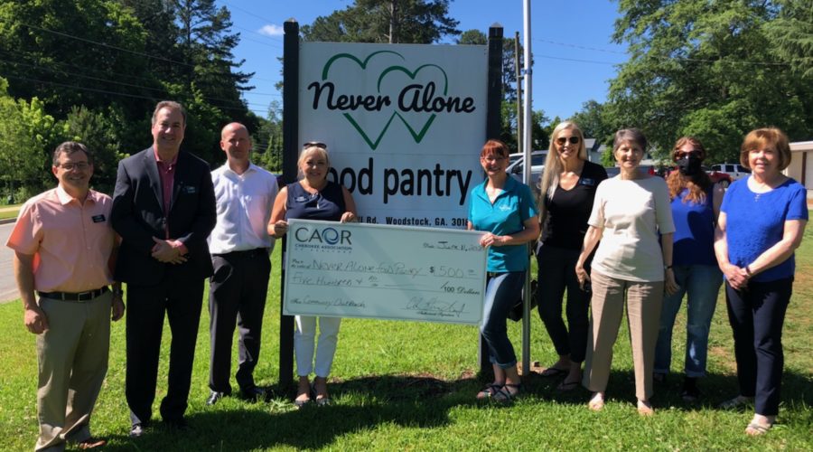 Cherokee Association of REALTORS® Give Back to the Community With a Donation to Never Alone Food Pantry
